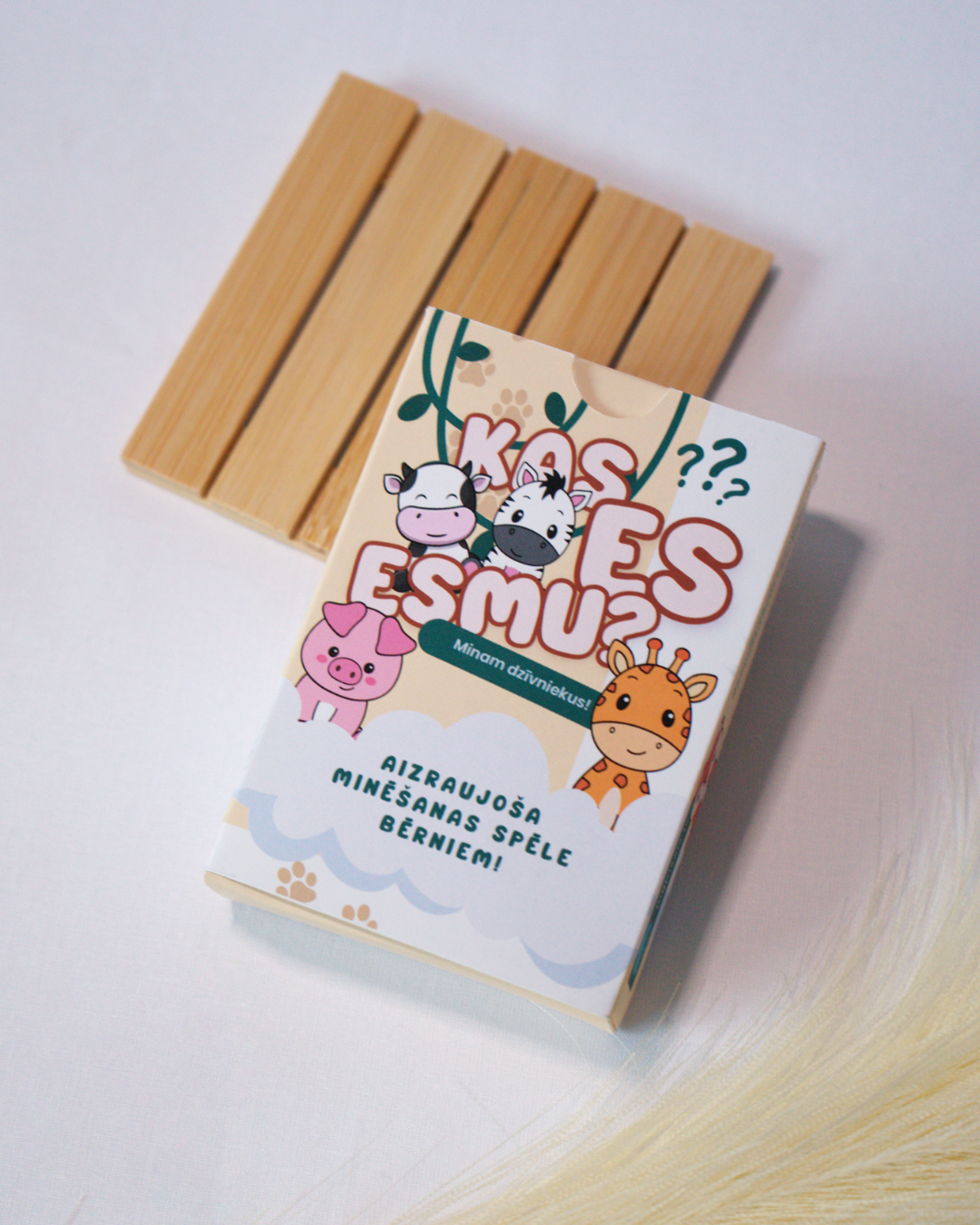 Children's game box with cartoon animals and wooden pieces on a light background